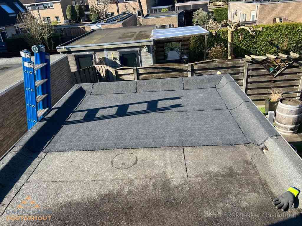 Dakdekker legt onderlaag op plat dak met houten constructie in Oosterhout