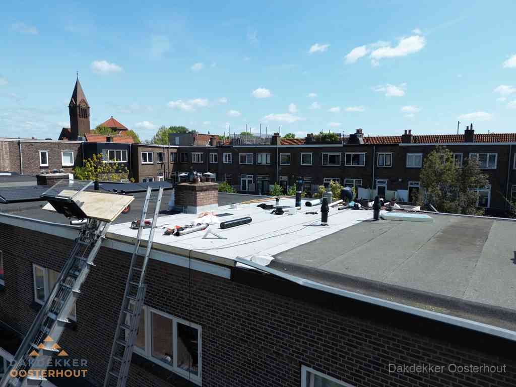Dakdekkers aan het werk op plat dak in Oosterhout