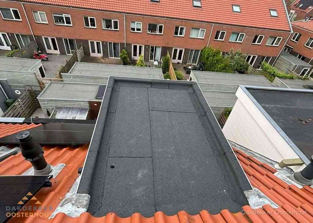 Plat dak met bitumen bedekking naast dakkapel in Oosterhout