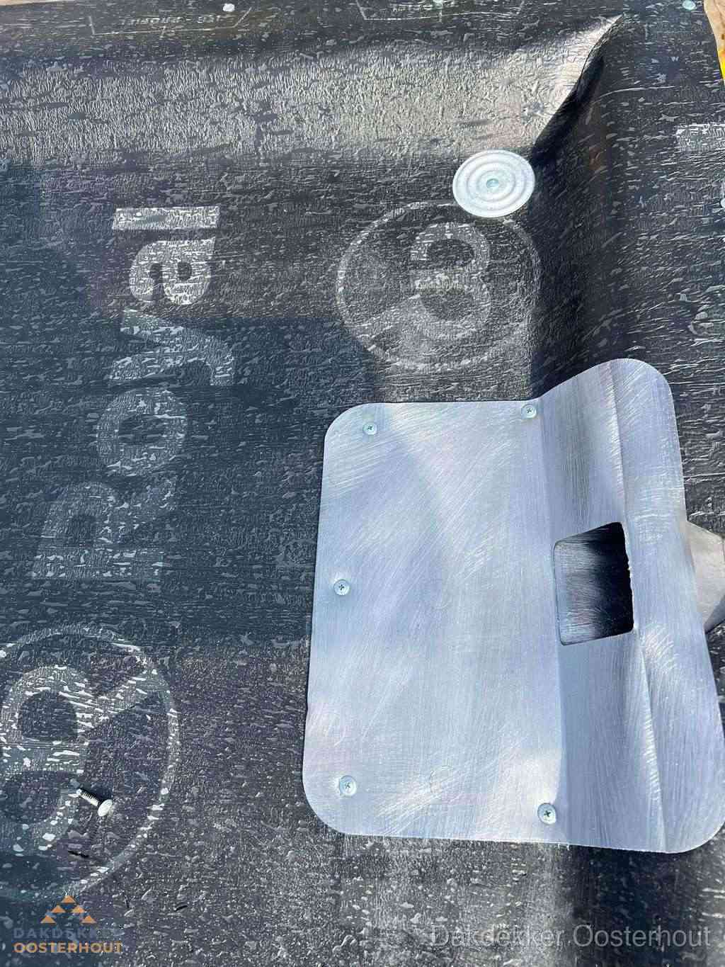 Dakdoorvoer met metalen afvoerplaat op bitumen dak in Oosterhout