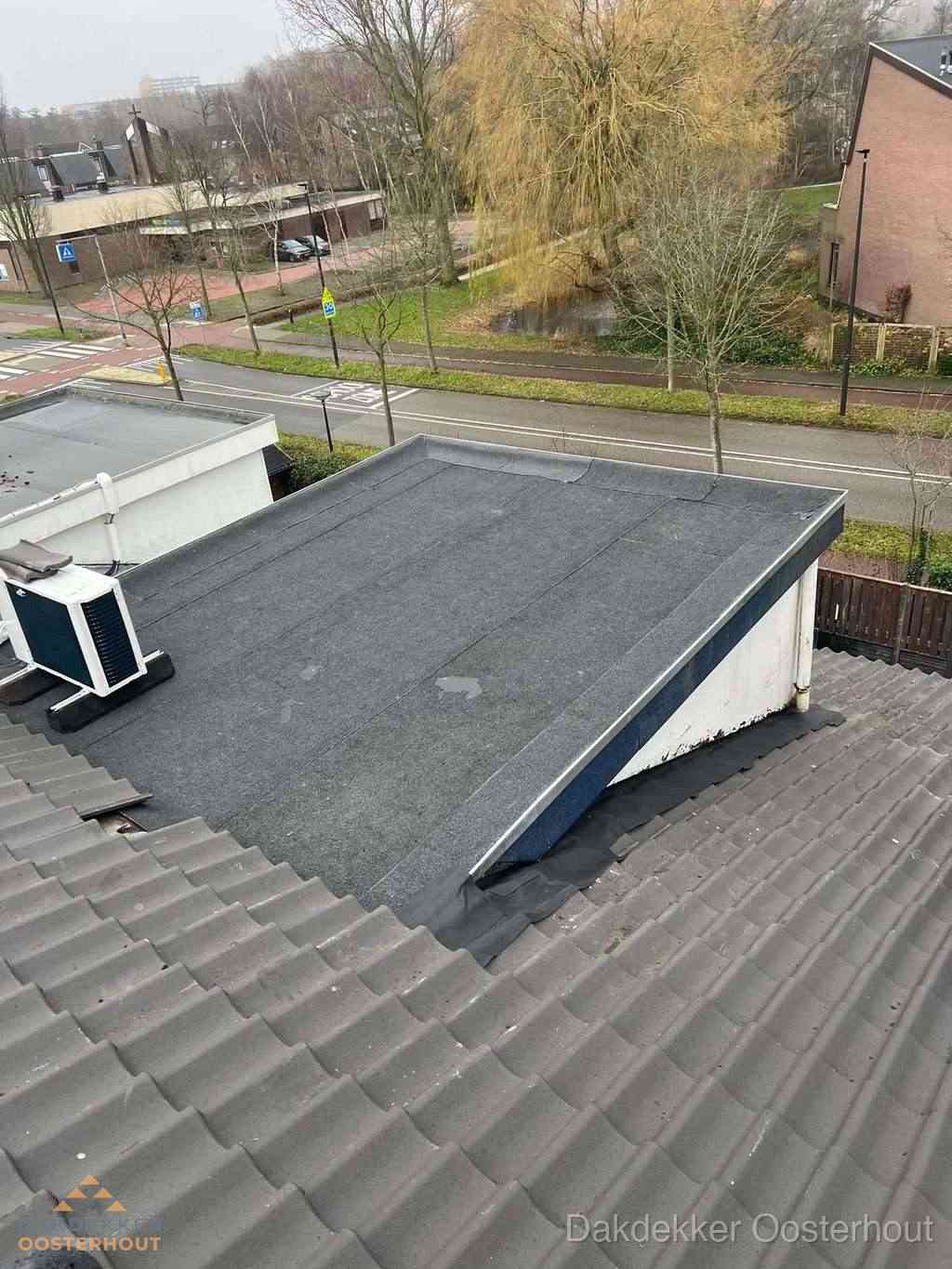 Plat dak met bitumen dakbedekking naast schuin pannendak in Oosterhout