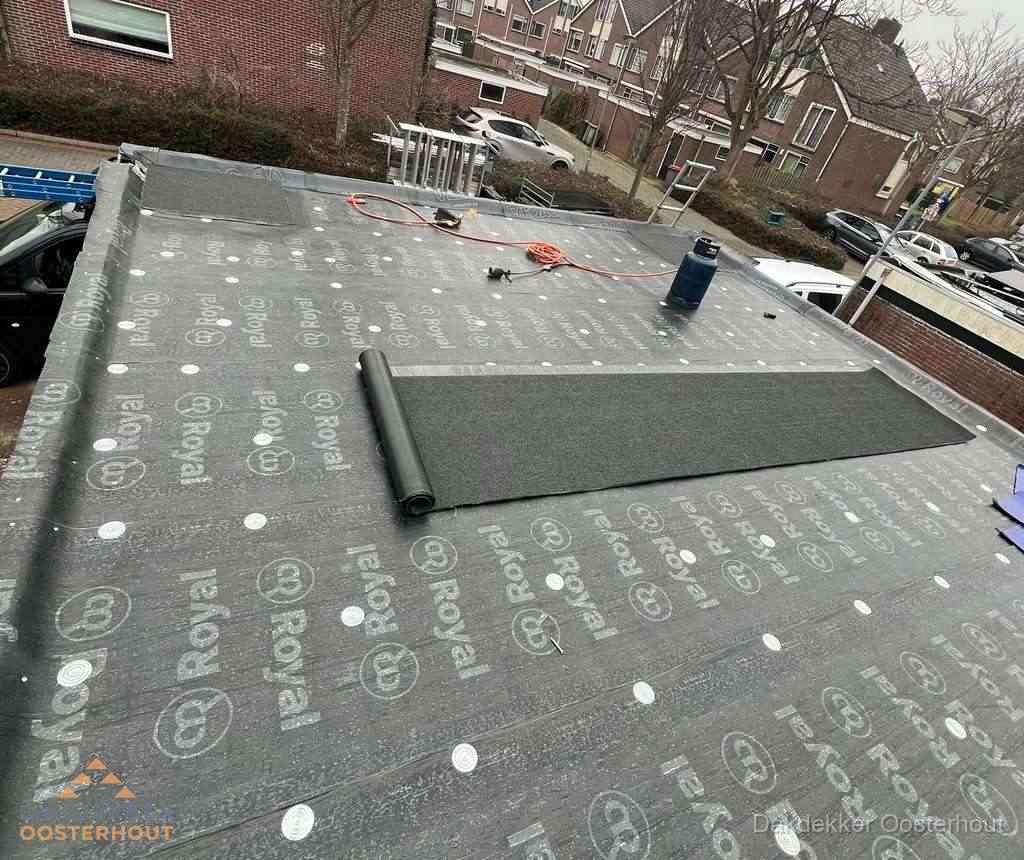 Dakdekker aan het werk met gasbrander op plat bitumen dak in Oosterhout